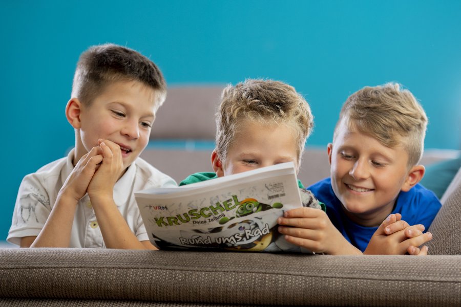 drei Jungs auf der Couch lesen die Zeitung Kruschel