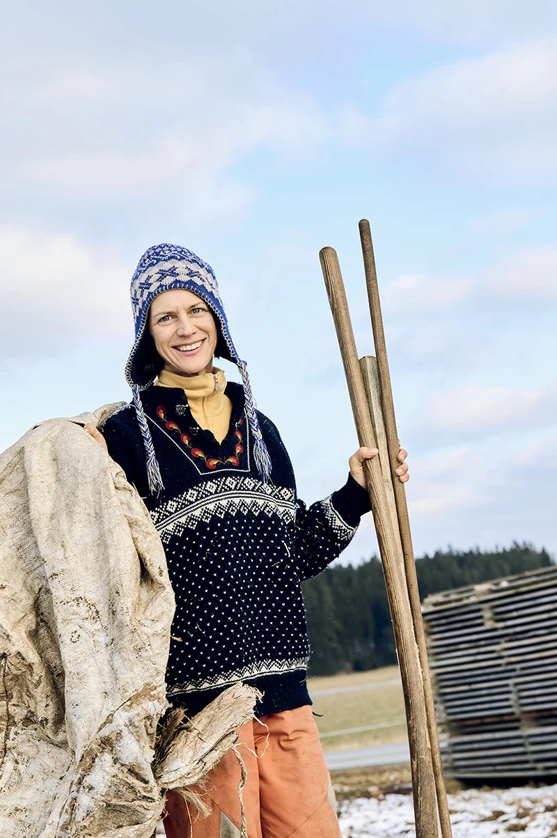 Porträt Bäuerin in buntem Strickpullover mit Werkzeug in der Hand. Foto: Nathalie Zimmermann