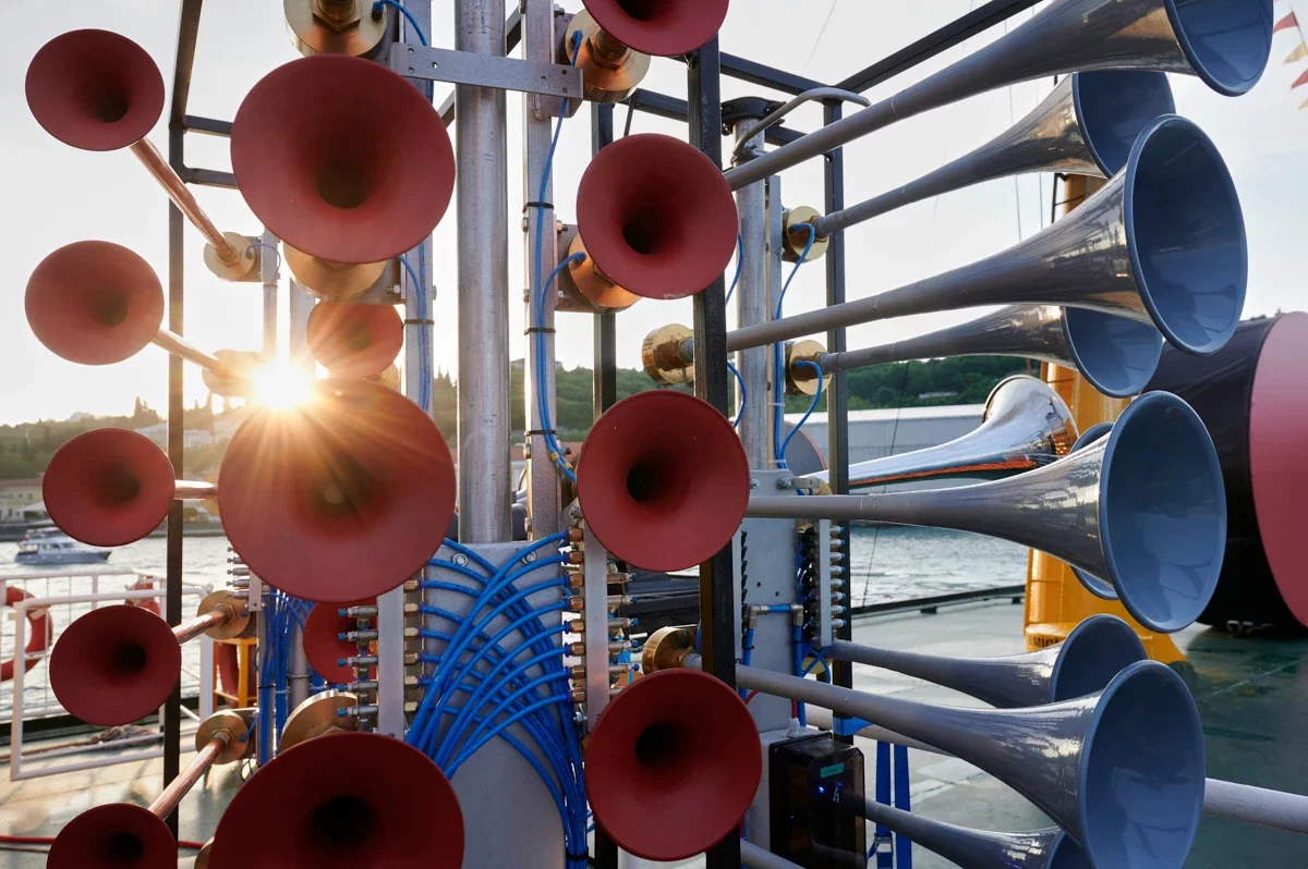 Verschiedene Signalhörner mit Sonne im Gegenlicht auf dem Schiff